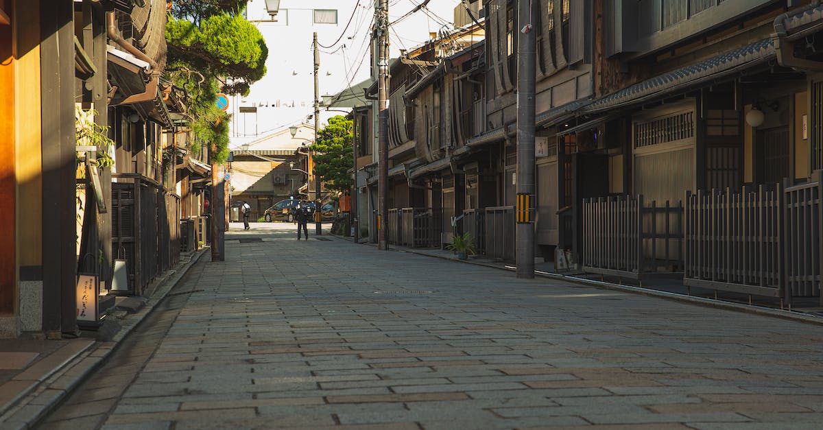 Can I find suitable (and affordable) accommodation in Japan with children? - Empty paved street in historic district of Kyoto with aged residential houses on sunny day Can I find suitable (and affordable) accommodation in Japan with children? - Empty paved street in historic district of Kyoto with aged residential houses on sunny day