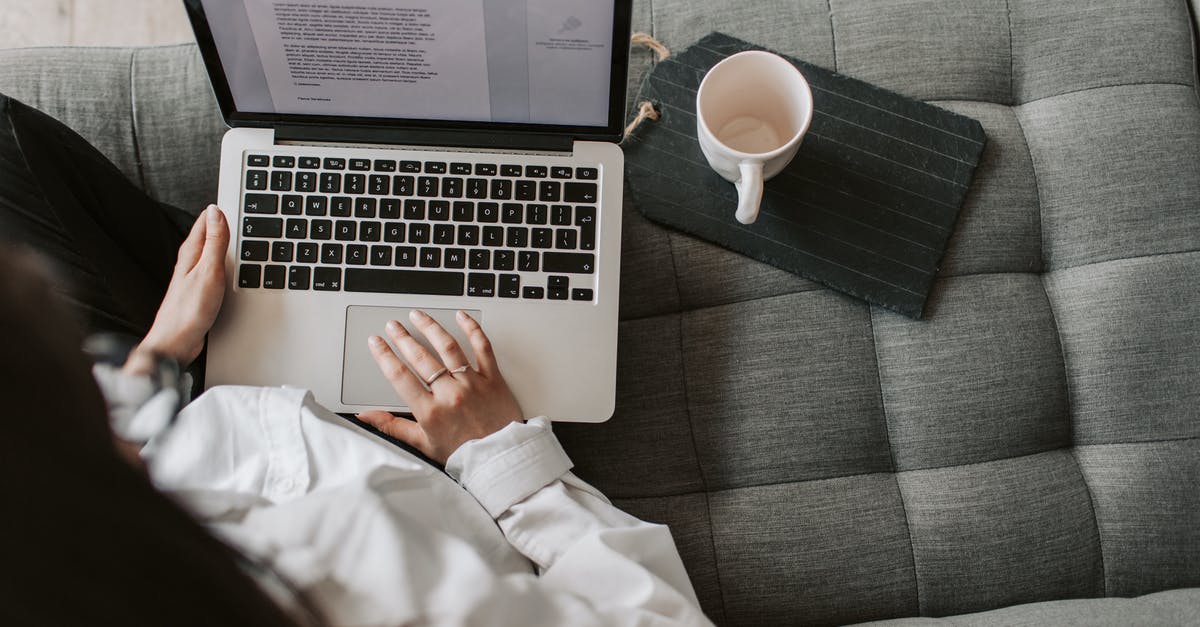 Can I get a visitor visa invitation from a non UK student living in the UK? - From above of woman in casual wear sitting on comfortable couch with cup and typing on keyboard of laptop while working remotely in cozy living room