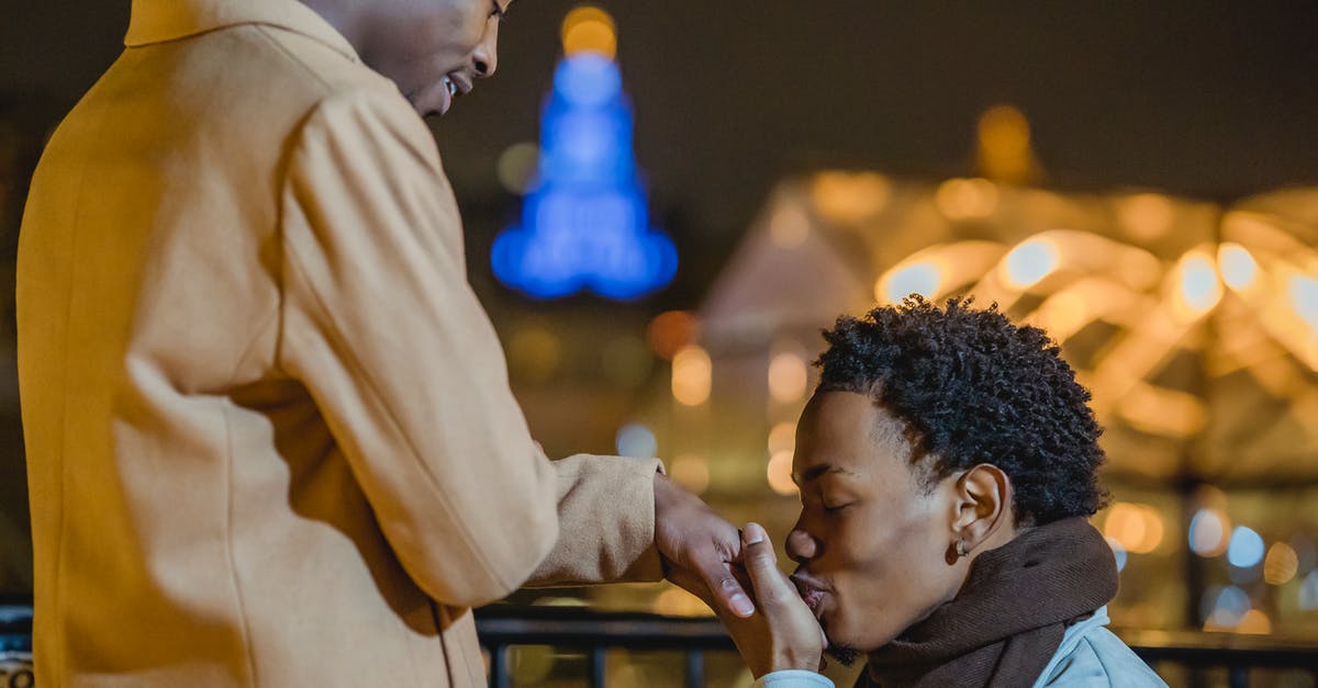 Can I have a same sex marriage to my partner who is overseas? [duplicate] - Side view of African American gay making propose of marriage to crop lover on bridge against blurred city lights at night