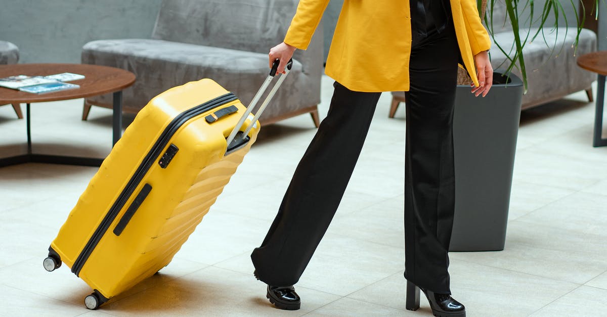Can I have an unregistered guest come over at a hotel? - Person in Yellow Coat Pulling a Suitcase