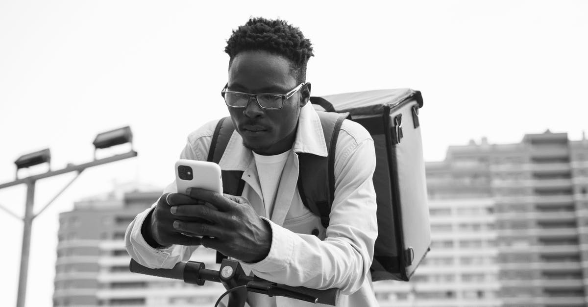 Can I hire a mobility scooter in Dortmund? - Grayscale Photo of a Delivery Person Using a Cellphone