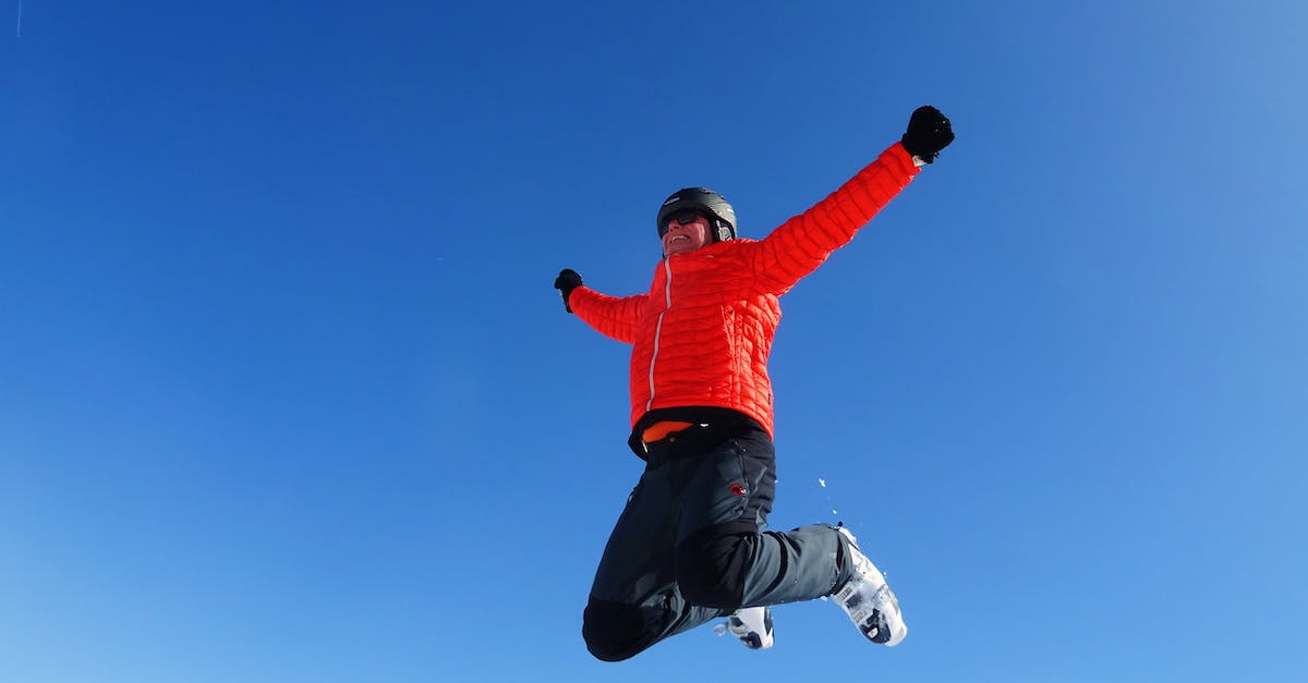 Can I learn ski jumping in Japan? - Man in Orange Zip Jacket and Black Pants Jumping Under Blue Sunny Sky Can I learn ski jumping in Japan? - Man in Orange Zip Jacket and Black Pants Jumping Under Blue Sunny Sky