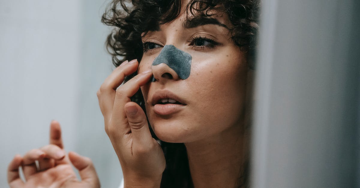 Can I legally remove my mask once my train cross the Italian-Swiss border? - Mirror reflection of young female with curly hair putting nose strip mask on face in bathroom Can I legally remove my mask once my train cross the Italian-Swiss border? - Mirror reflection of young female with curly hair putting nose strip mask on face in bathroom