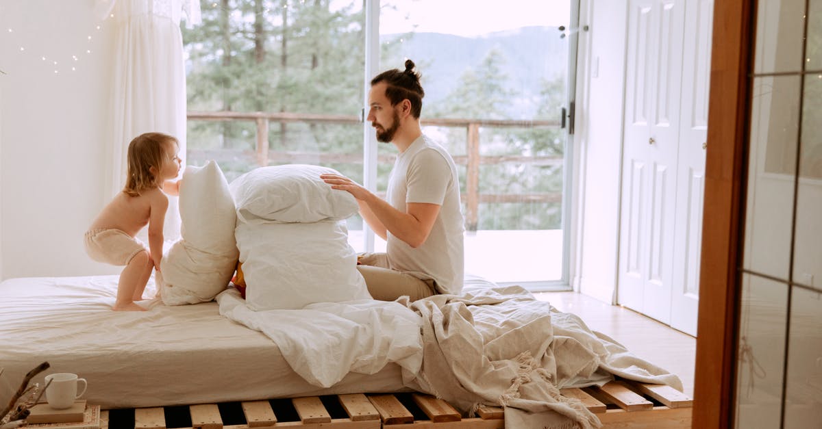 Can I put a bed quilt/blanket in airplane's cargo? - Side view of serious bearded father in casual clothes playing with little child with pillows on comfortable bed in light bedroom at home Can I put a bed quilt/blanket in airplane's cargo? - Side view of serious bearded father in casual clothes playing with little child with pillows on comfortable bed in light bedroom at home