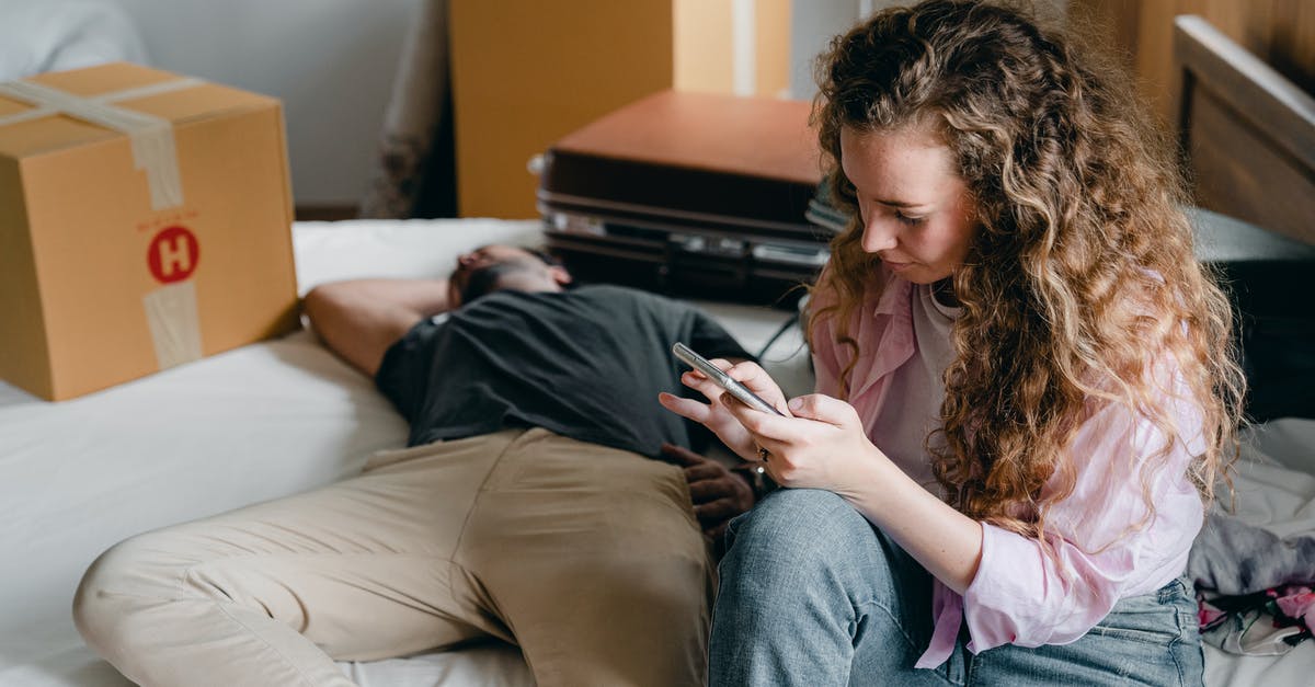 Can I put new wrist watch in checked or carry-on bag? - Woman and man on bed in new apartment Can I put new wrist watch in checked or carry-on bag? - Woman and man on bed in new apartment