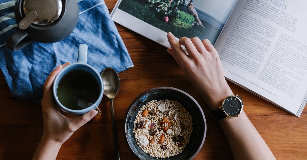 Can I put new wrist watch in checked or carry-on bag? - Person Holding White Ceramic Coffee Cup Leaning on Brown Wooden Table Can I put new wrist watch in checked or carry-on bag? - Person Holding White Ceramic Coffee Cup Leaning on Brown Wooden Table