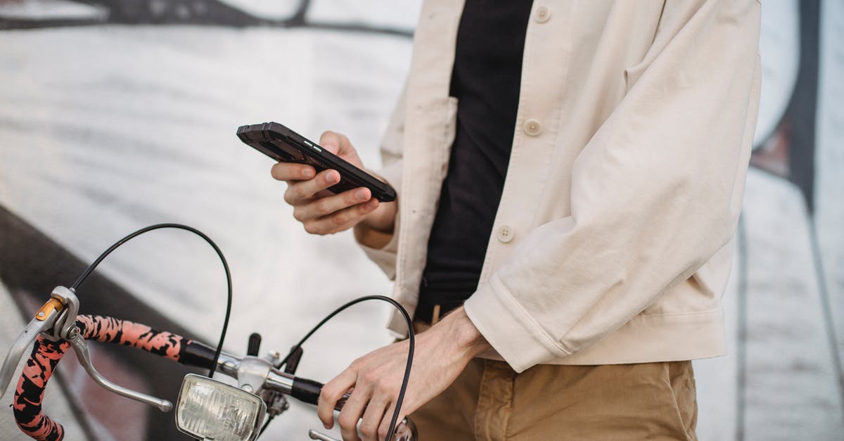 Can I ride on the Gatwick monorail after bag-drop/check in? - Anonymous man using smartphone while standing on street near bicycle Can I ride on the Gatwick monorail after bag-drop/check in? - Anonymous man using smartphone while standing on street near bicycle