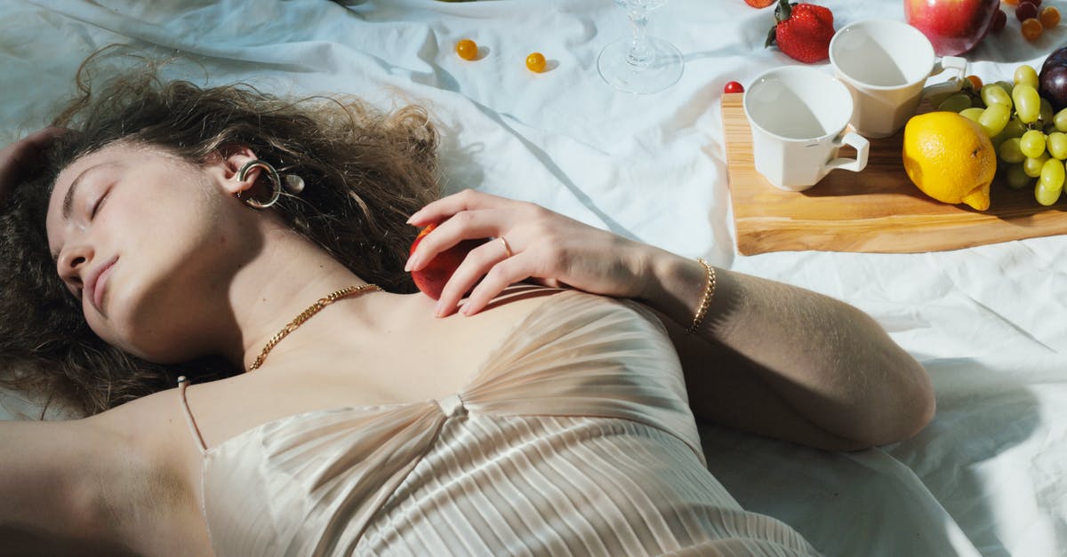 Can I sleep on a airplane tray table? - Relaxed woman with fruit lying on blanket Can I sleep on a airplane tray table? - Relaxed woman with fruit lying on blanket
