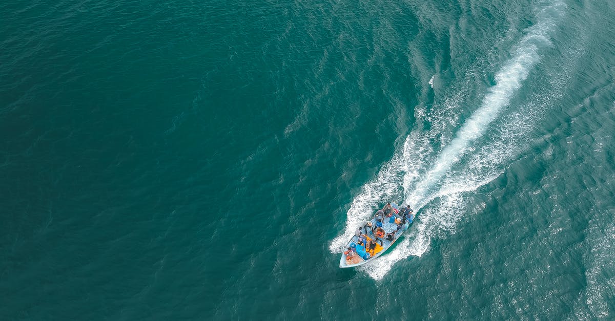 Can I still travel to HK with a 5 year travel ban from China? - Aerial view of boat with open deck floating on tranquil sea at daytime