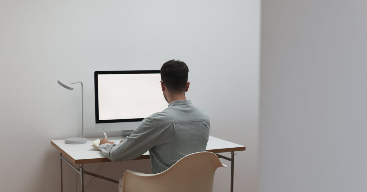 Can I take a 24" computer monitor on board? - Unrecognizable man working on computer at home Can I take a 24" computer monitor on board? - Unrecognizable man working on computer at home