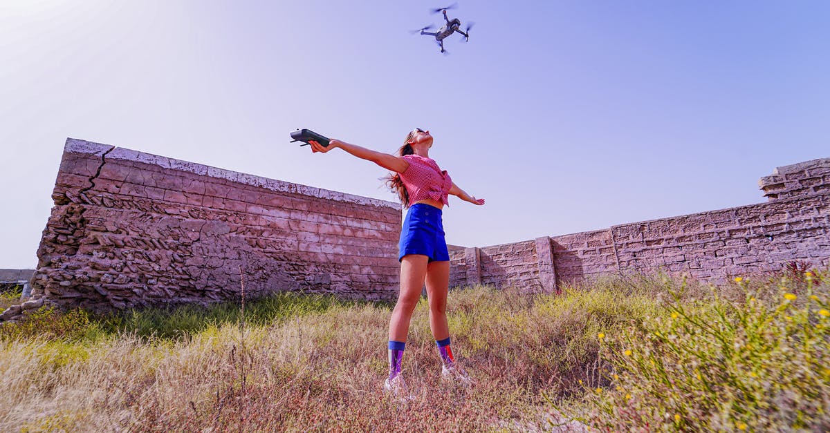 Can i take my drone to Lombok and fly there? - Fit woman standing with arms outstretched under flying drone Can i take my drone to Lombok and fly there? - Fit woman standing with arms outstretched under flying drone