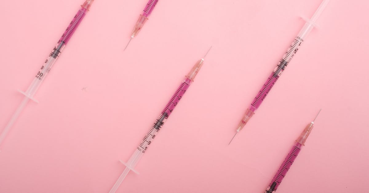 Can I take my liquid medication on a plane? - Top view set of syringes with purple colored liquid medicine arranged on pink background as background Can I take my liquid medication on a plane? - Top view set of syringes with purple colored liquid medicine arranged on pink background as background