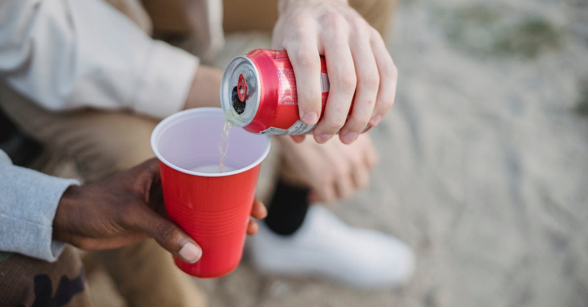 Can I transit via Schengen with visa-free days expired? - From above of crop anonymous man pouring fizzy drink from can into red plastic cup of black friend while sitting on sandy ground Can I transit via Schengen with visa-free days expired? - From above of crop anonymous man pouring fizzy drink from can into red plastic cup of black friend while sitting on sandy ground