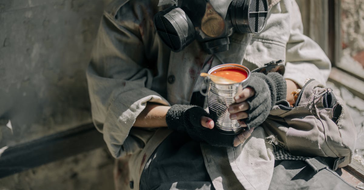 Can I transport canned food in hand luggage in Europe? - Person in Gray Jacket Holding White and Red Ceramic Mug Can I transport canned food in hand luggage in Europe? - Person in Gray Jacket Holding White and Red Ceramic Mug