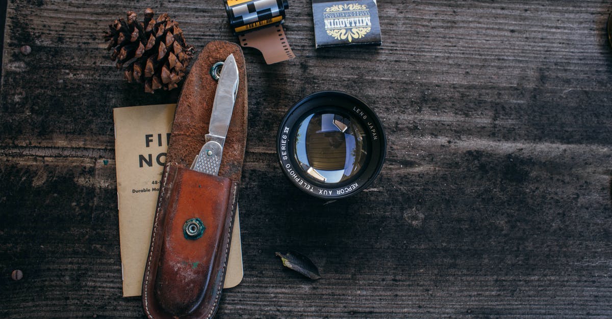 Can I trasport a small set of tools with me in the airplane? - Lens near camera roll and knife near cone on table Can I trasport a small set of tools with me in the airplane? - Lens near camera roll and knife near cone on table