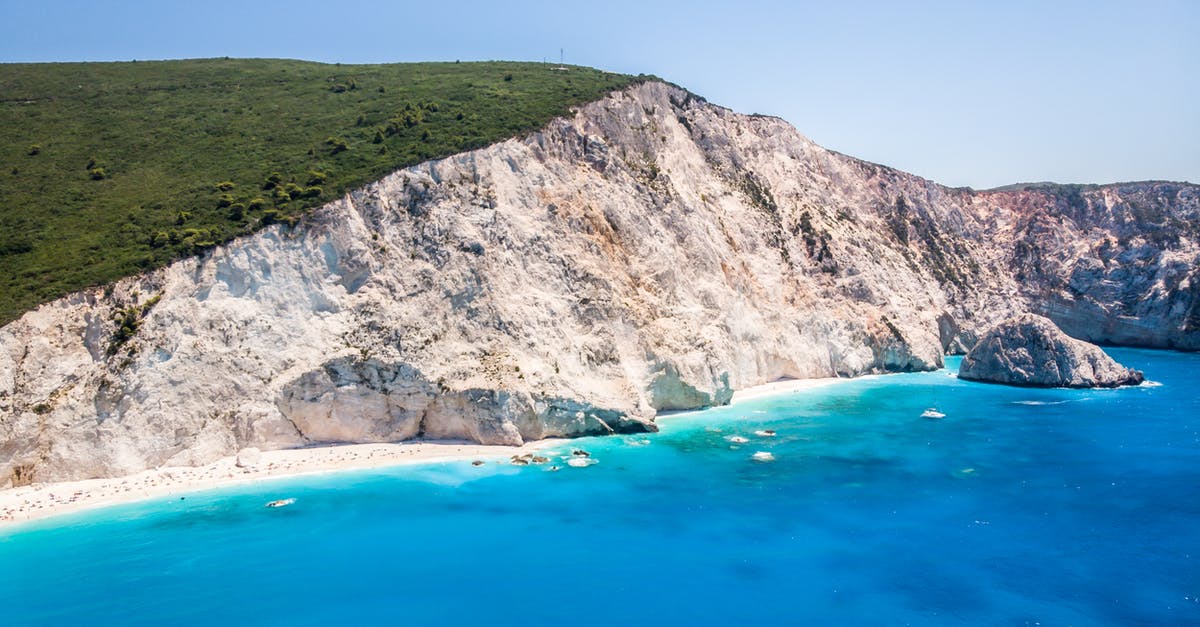 Can I travel to Greece if I've overstayed my trip in Romania? - Picturesque turquoise sea washing sandy beach surrounded by white rocky cliff Can I travel to Greece if I've overstayed my trip in Romania? - Picturesque turquoise sea washing sandy beach surrounded by white rocky cliff