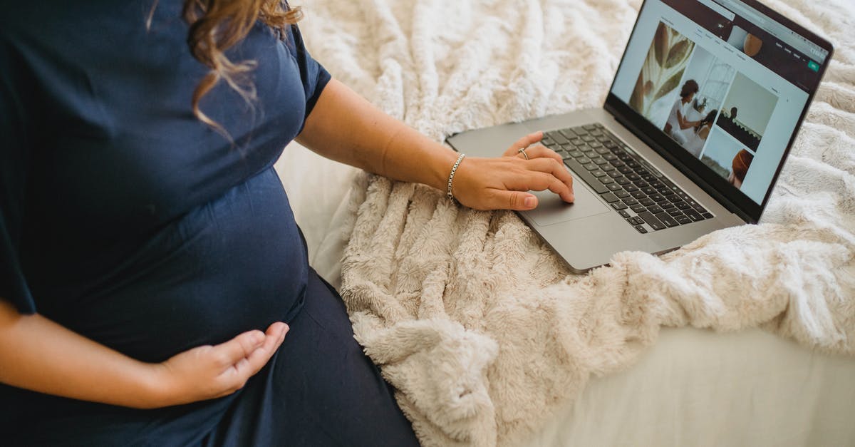 Can I use a permanent disability certificate as photo ID for a domestic flight in India? [duplicate] - From above of crop anonymous expectant female caressing belly while surfing internet on netbook on cozy bed