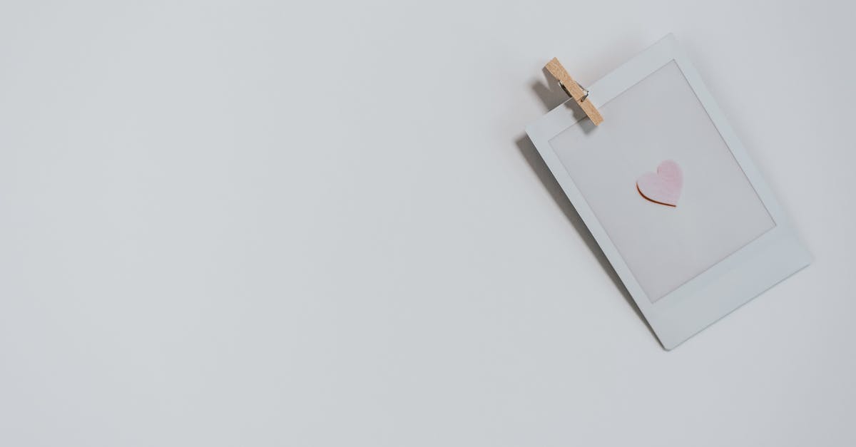 Can I use my TWIC card as my photo ID to fly from Philadelphia to Las Vegas? - Top view of photo with small pink heart with wooden photo paper peg pin placed on white background during holiday celebration