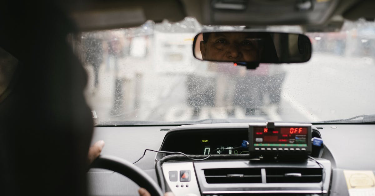 Can my licensed NY driver, age 17, drive in VA? - Back view of man reflecting in mirror while driving along street in city on urban background in soft daylight