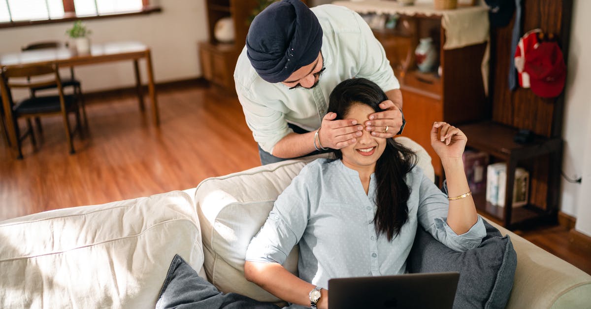 Can my wife join me (I have a Tier 4 student visa) for a month from India using a tourist visa? - From above of young Indian woman in casual wear resting on comfortable couch with laptop in modern apartment while Indian boyfriend standing behind and closing eyes girlfriend with hands Can my wife join me (I have a Tier 4 student visa) for a month from India using a tourist visa? - From above of young Indian woman in casual wear resting on comfortable couch with laptop in modern apartment while Indian boyfriend standing behind and closing eyes girlfriend with hands