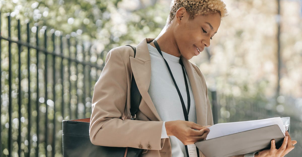 Can Singapore ban me because I left a contract position on short notice? - Content ethnic businesswoman looking through papers Can Singapore ban me because I left a contract position on short notice? - Content ethnic businesswoman looking through papers
