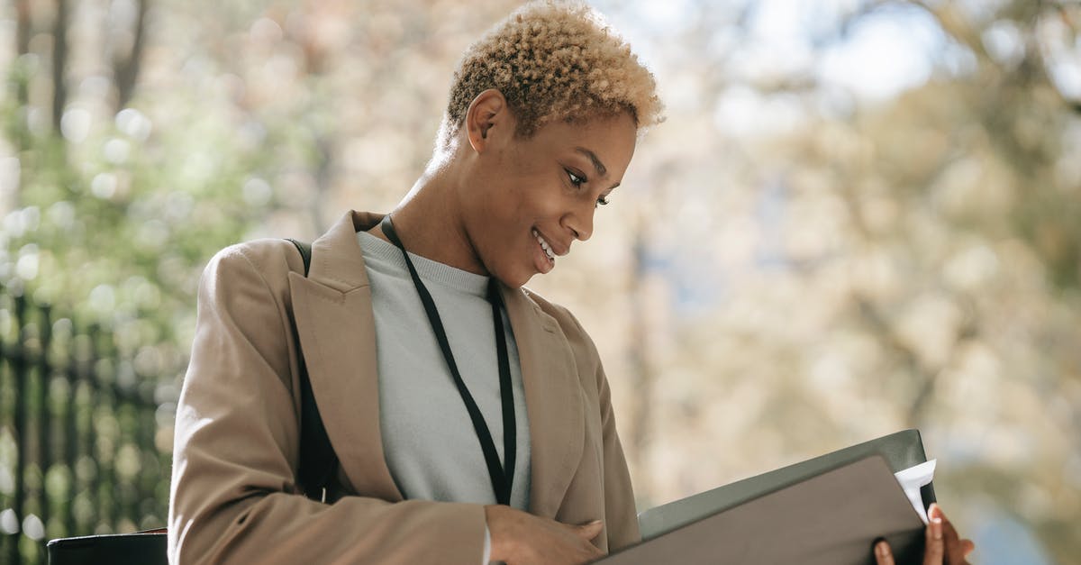 Can Singapore ban me because I left a contract position on short notice? - Cheerful businesswoman reading documents in folder Can Singapore ban me because I left a contract position on short notice? - Cheerful businesswoman reading documents in folder