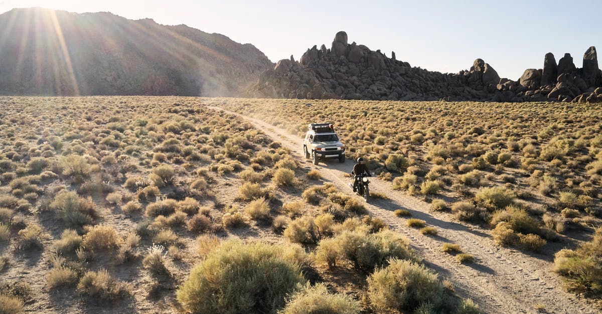 Can someone travel from outside the Schengen area into the Schengen area just as a transit passenger without holding any Schengen visa? - From above view of narrow road in dry highland valley with jeep and motorbike under bright evening sun
