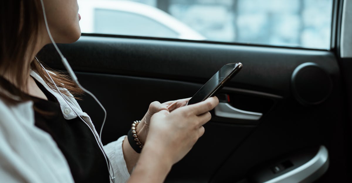 Can we use the "EU citizen only" lane when travelling by car with one non-EU passenger inside? - Crop unrecognizable woman listening to music on smartphone in car