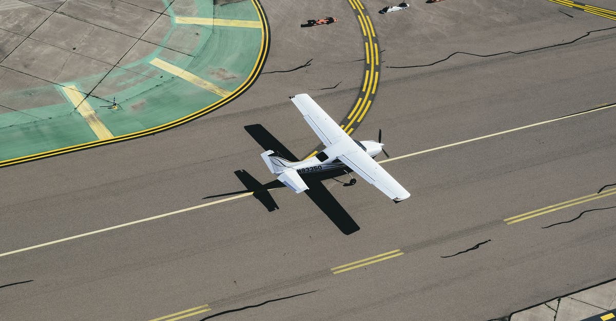 Can you bring an adjustable spanner on an airplane from Åland? - From above of small biplane landing on runway with cracks and yellow markings on summer sunny day Can you bring an adjustable spanner on an airplane from Åland? - From above of small biplane landing on runway with cracks and yellow markings on summer sunny day