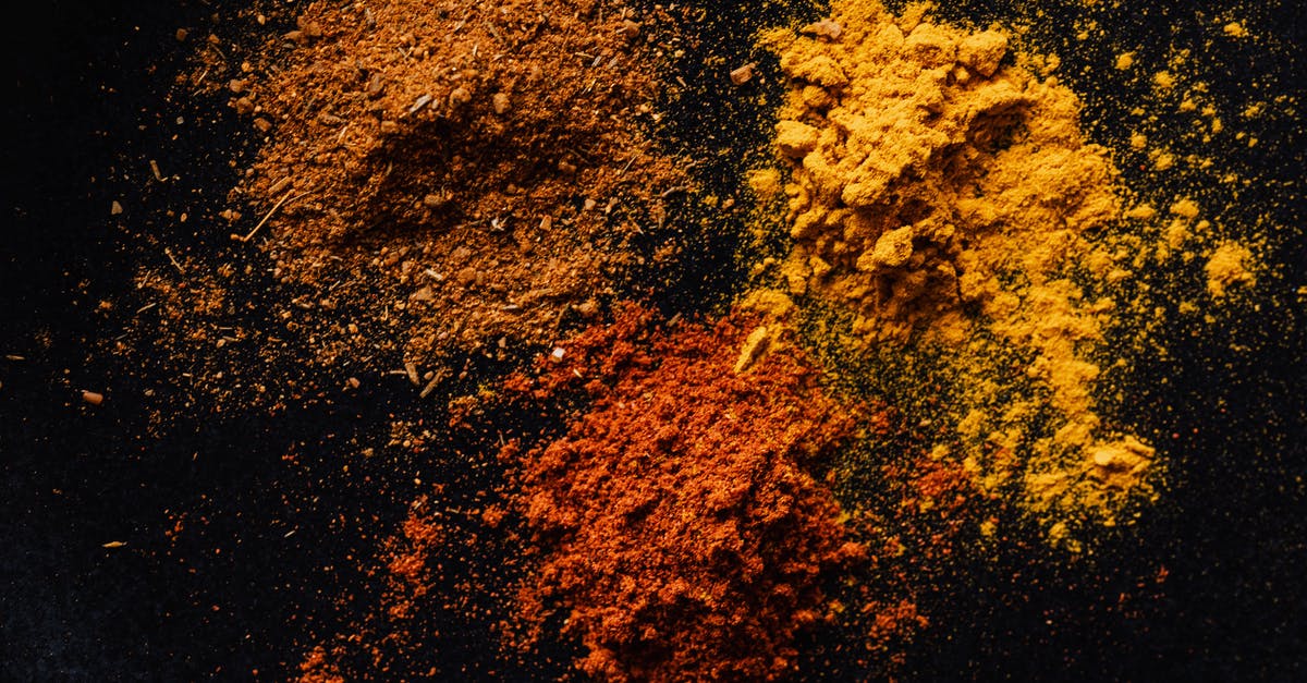 Can you bring chili powder into the US? - Assorted colorful dry powdered spices on black background Can you bring chili powder into the US? - Assorted colorful dry powdered spices on black background