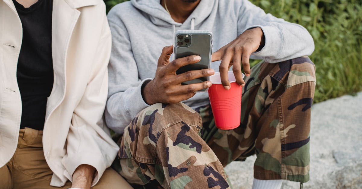 Can you bring tax-free alcohol on Air Iceland Connect? - Crop positive African American male browsing mobile phone while drinking beer from red cups with friend Can you bring tax-free alcohol on Air Iceland Connect? - Crop positive African American male browsing mobile phone while drinking beer from red cups with friend