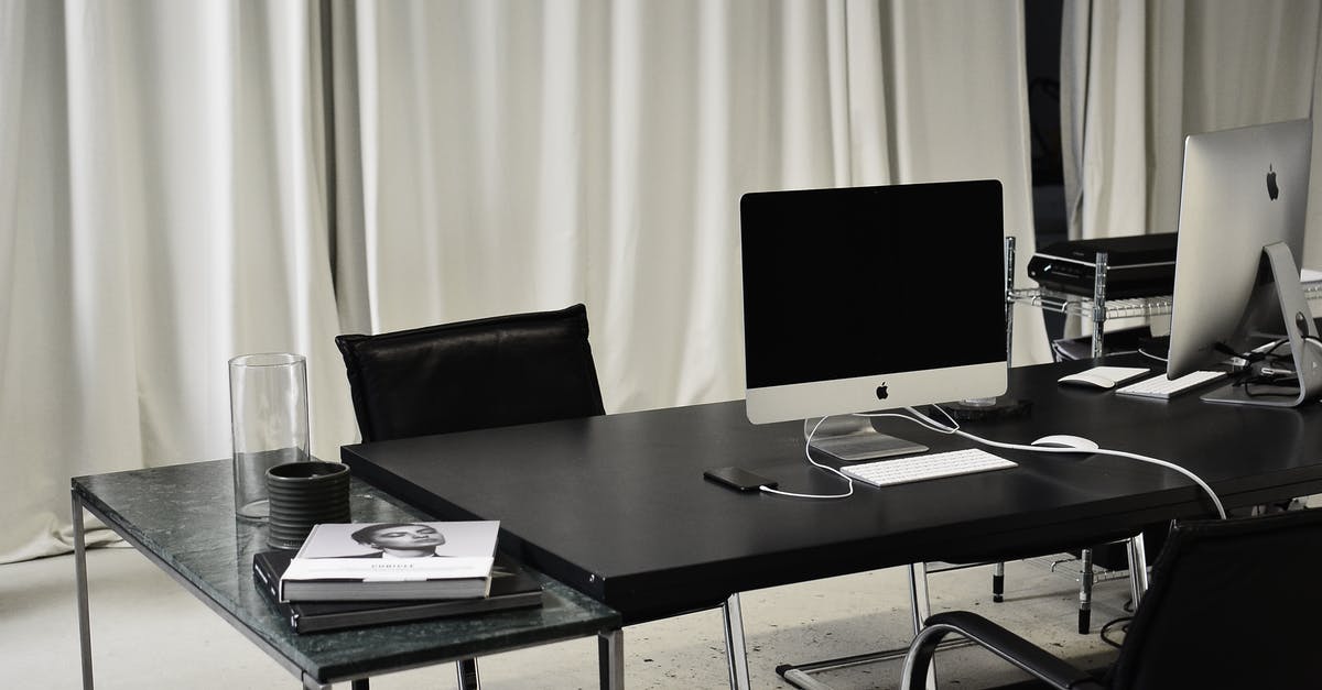Can you charge your phone "airside" at Malaga Airport (AGP) - Black and white of workspace of office with computers placed on table with wireless mouse and keyboard near smartphone Can you charge your phone "airside" at Malaga Airport (AGP) - Black and white of workspace of office with computers placed on table with wireless mouse and keyboard near smartphone