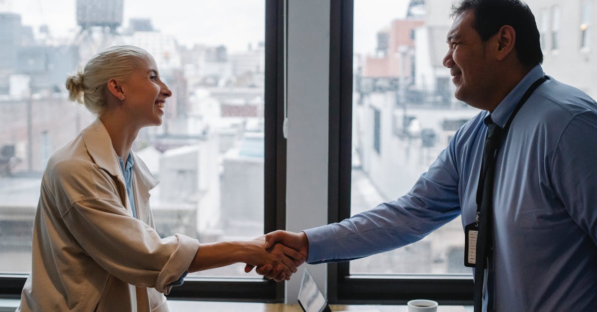 Can you escape a contract if an airline maltreated its other customers? - Cheerful colleagues shaking hands while standing at table