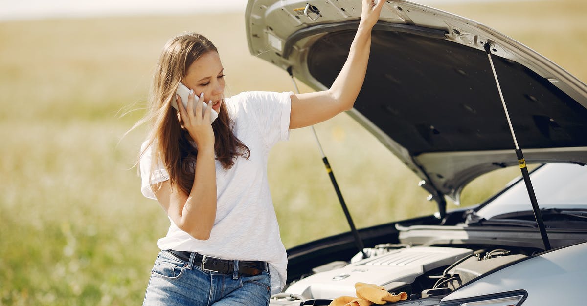 Can you get a gate pass at LAX to help someone who doesn't speak English? - Upset woman using smartphone near broken automobile in countryside during car trip
