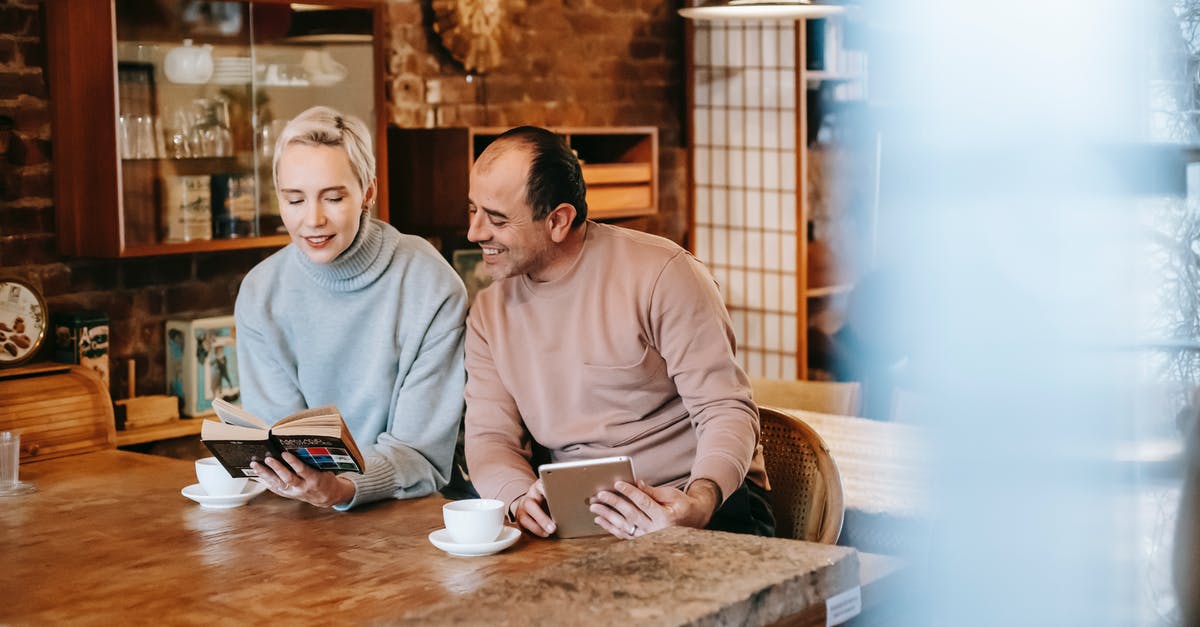 Can you please share the link to book appointment at italian consulate in san francisco [closed] - Woman reading book for ethnic husband browsing tablet at table