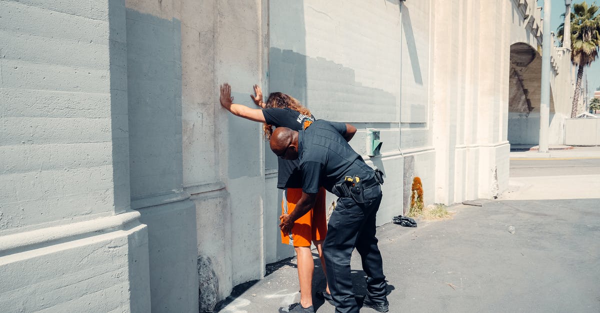 Can you request a frisk search be performed by an opposite sex officer at the airport? - An Officer Frisking a Man Can you request a frisk search be performed by an opposite sex officer at the airport? - An Officer Frisking a Man