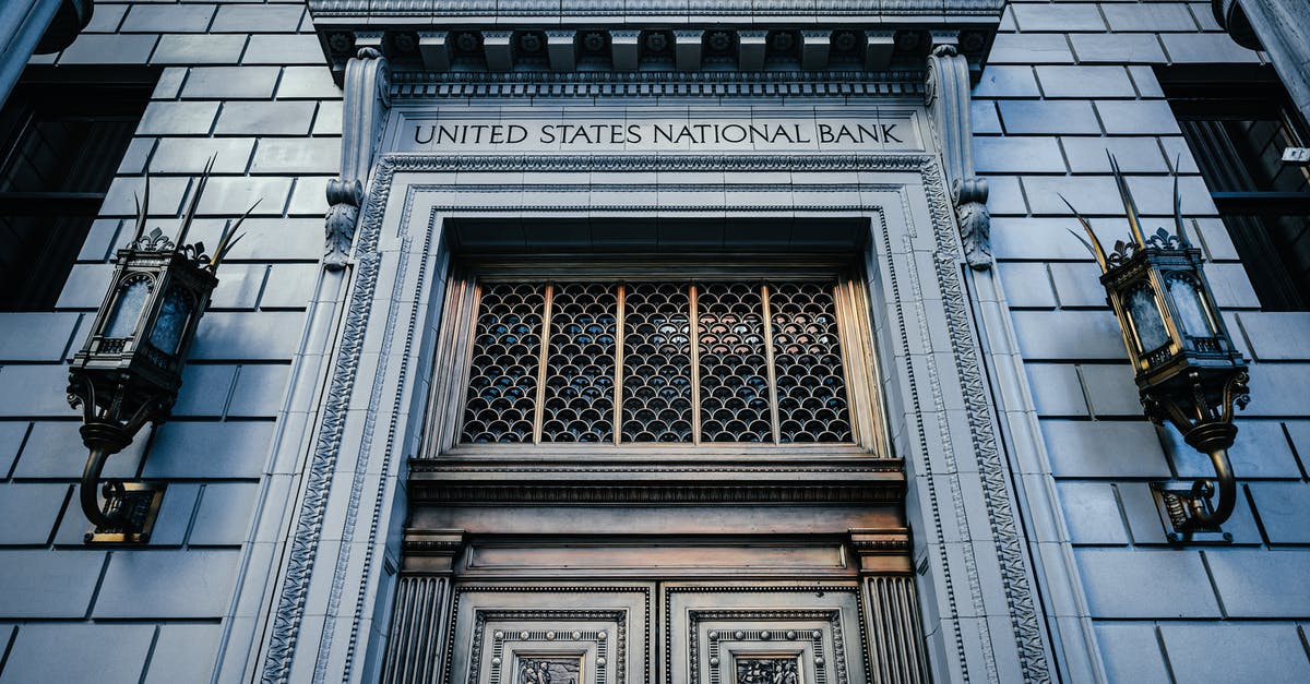 Can you sightsee in Portland, Oregon without a car? - From below classic styled historic building of United States National Bank with wooden doors and vintage lanterns located in Portland Can you sightsee in Portland, Oregon without a car? - From below classic styled historic building of United States National Bank with wooden doors and vintage lanterns located in Portland