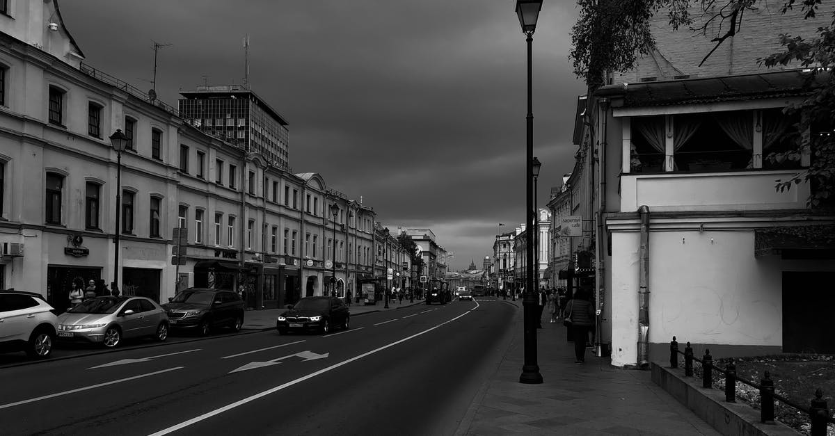 Can you suggest a route to travel from Moscow to Siberia and return in 2 weeks? [closed] - Vehicles parked on city street near old buildings on cloudy day