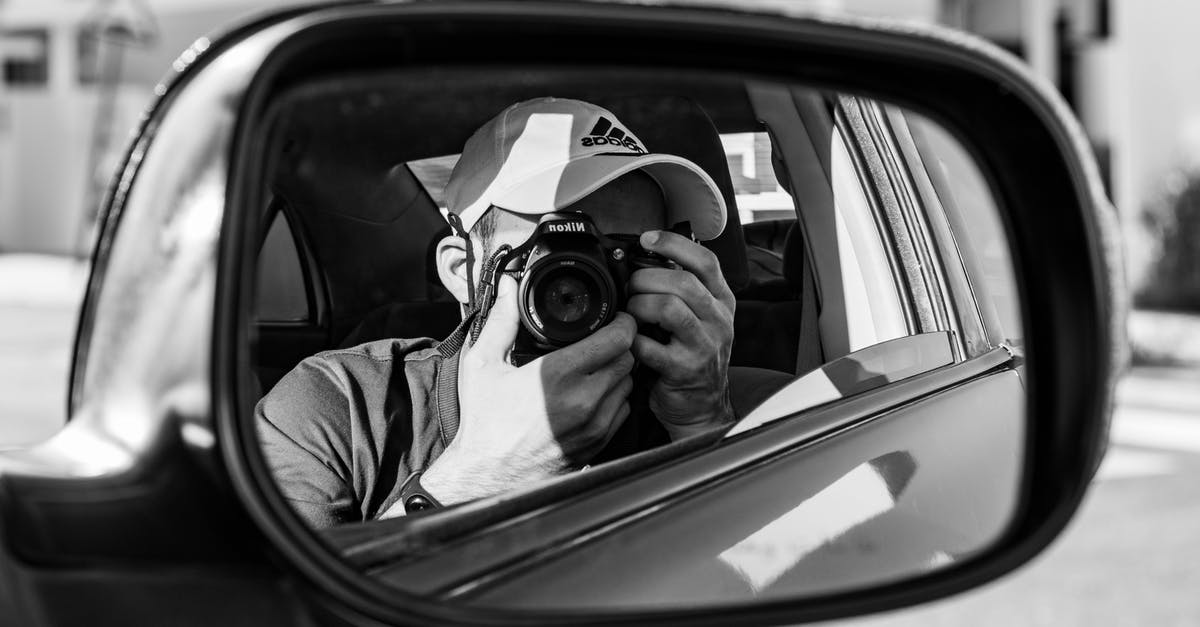 Can you use a camera during take off and landing? - Grayscale Photo of Man in Jacket Holding Camera