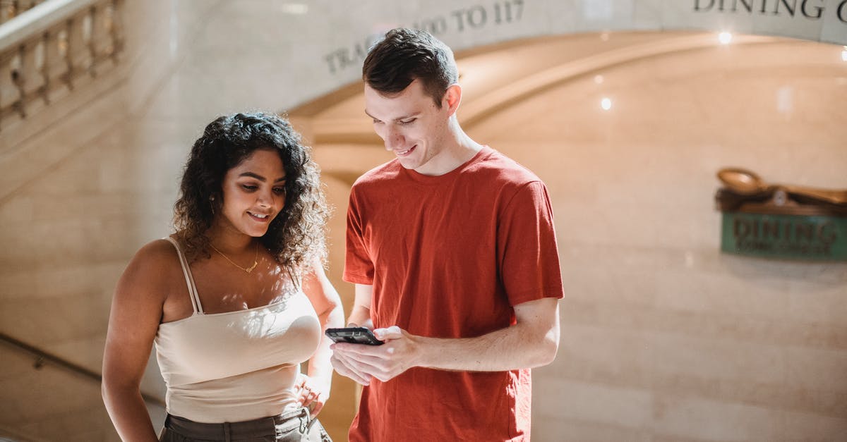 Canadian citizen traveling to USA on British Passport using ESTA - Positive young multiethnic couple browsing smartphone during trip in New York Canadian citizen traveling to USA on British Passport using ESTA - Positive young multiethnic couple browsing smartphone during trip in New York
