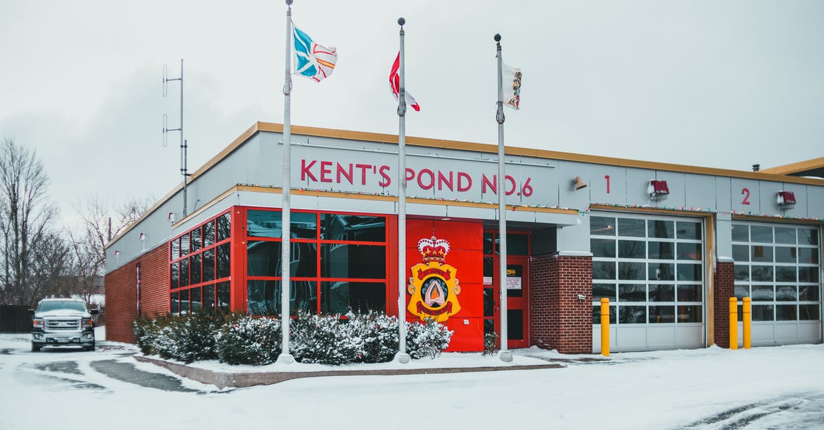 Canadian Permanent Resident entering Canada with expired US passport - Building facade against flags in winter city Canadian Permanent Resident entering Canada with expired US passport - Building facade against flags in winter city