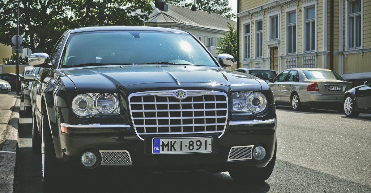 Canadian renting car in Finland and driving sports team members - Black Chrysler 300c Parked on Road Canadian renting car in Finland and driving sports team members - Black Chrysler 300c Parked on Road