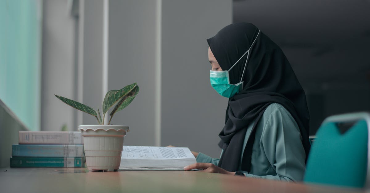 Cancelling booking on Booking.com due to COVID-19 - Woman in Black Hijab Reading a Book Cancelling booking on Booking.com due to COVID-19 - Woman in Black Hijab Reading a Book