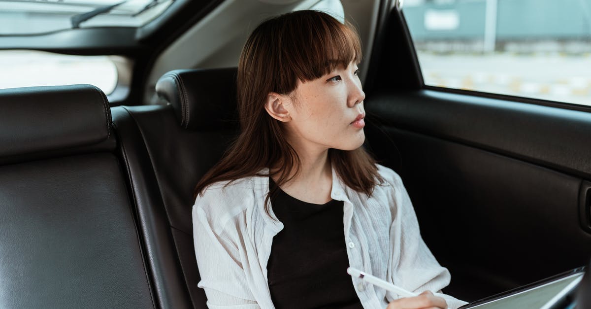 Cancelling Schengen Student Visa Application - Thoughtful young woman working on tablet with stylus in car Cancelling Schengen Student Visa Application - Thoughtful young woman working on tablet with stylus in car