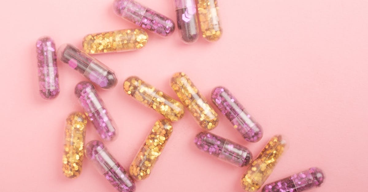 Capsule hotels in New-York JFK - Pile of sparkling drug capsules scattered on pink surface Capsule hotels in New-York JFK - Pile of sparkling drug capsules scattered on pink surface