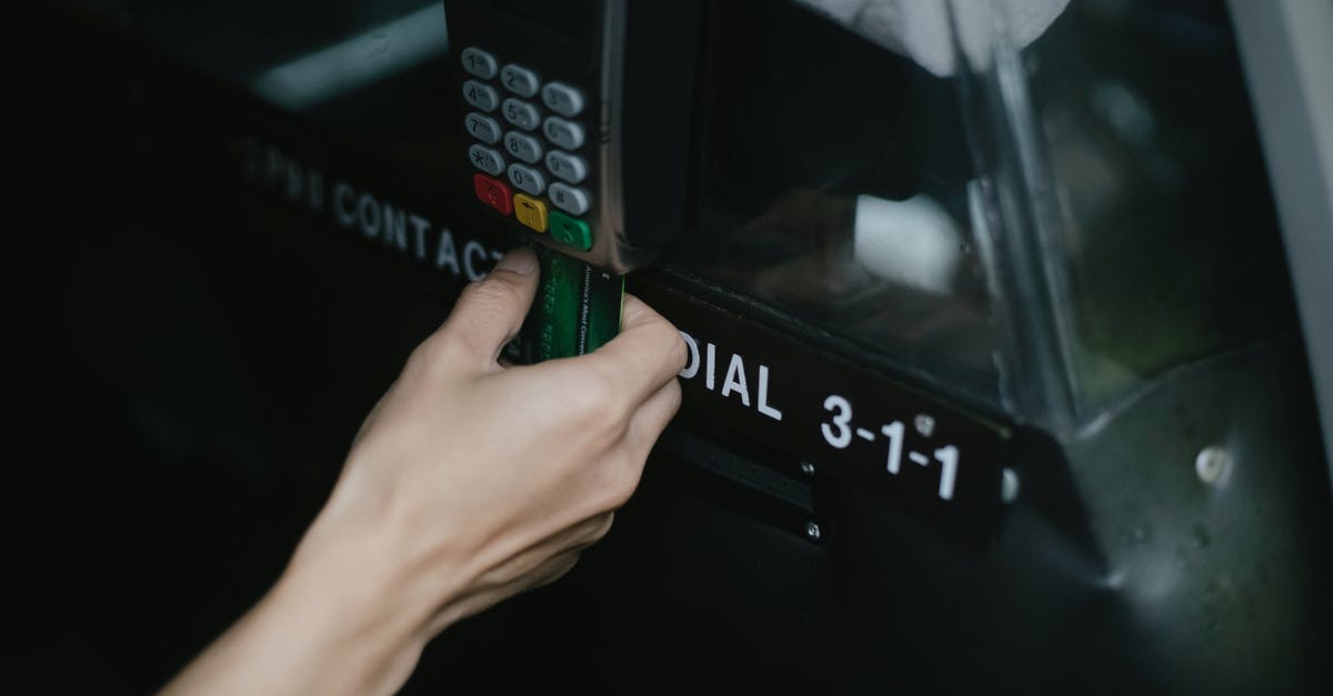 Car hire credit Card in Ireland - Crop anonymous traveler using card device while paying for taxi ride in automobile