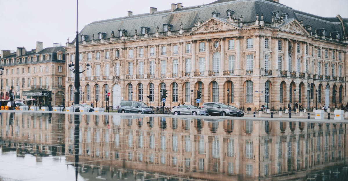 Car insurance in France for 100 days - Square with Garonne river and aged house facades near road with cars in Bordeaux Car insurance in France for 100 days - Square with Garonne river and aged house facades near road with cars in Bordeaux