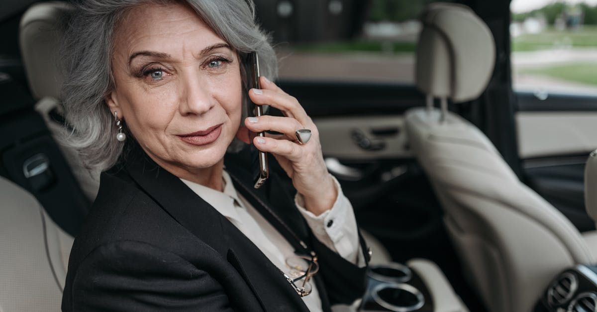 Car rental at 20 years old in UK - Woman in Black Blazer Holding Smartphone Car rental at 20 years old in UK - Woman in Black Blazer Holding Smartphone