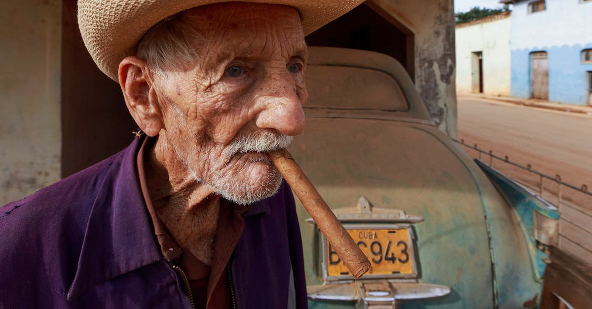 Car rental in Cuba - Man Wearing a Farmers Hat Smoking Cigar Car rental in Cuba - Man Wearing a Farmers Hat Smoking Cigar