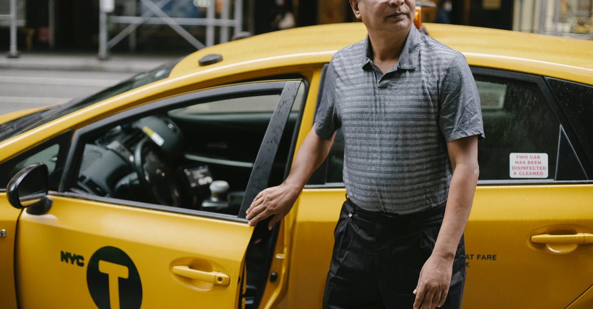Car rental in France with U.S. drivers license - Focused taxi driver at cab on street Car rental in France with U.S. drivers license - Focused taxi driver at cab on street